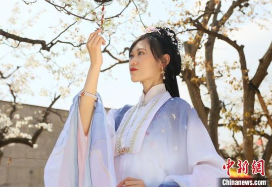 圖為蘭州青年身穿漢服在百年梨園賞景。 高展 攝 圖為蘭州青年身穿漢服在百年梨園賞景。 高展 攝