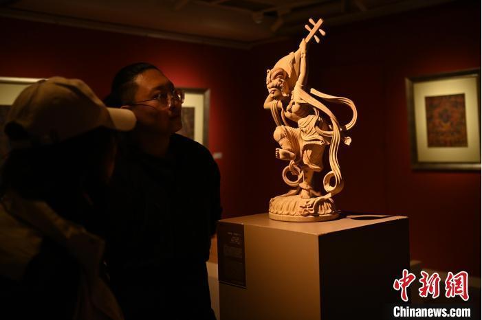 圖為季茂杰向參觀者介紹自己創作敦煌木雕的過程。李亞龍 攝</p>
<p> 圖為季茂杰向參觀者介紹自己創作敦煌木雕的過程。李亞龍 攝</p>
<p>