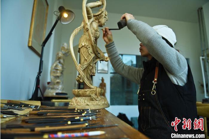 圖為季茂杰進行敦煌元素的木雕創作。李亞龍 攝</p>
<p> 圖為季茂杰進行敦煌元素的木雕創作。李亞龍 攝</p>
<p>