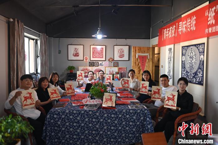 6月6日,在甘肅敦煌青年夜校課程中,青年學員展示學習敦煌非遺剪紙的成果。