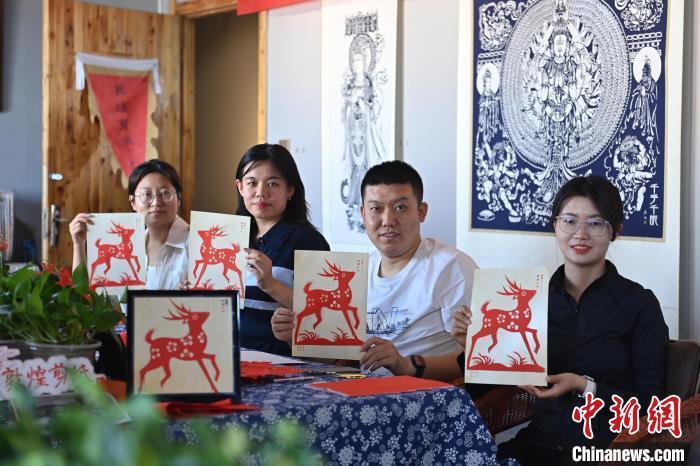 6月6日,在甘肅敦煌青年夜校課程中,青年學員展示學習敦煌非遺剪紙的成果。李亞龍 攝